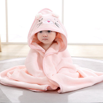 Child wearing a pink hooded towel with cat ears and a nose on a light background